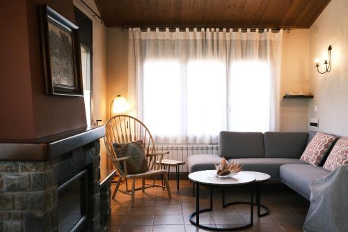 un soggiorno con divano e camino di Casa Rural Graner a Sant Llorenç de Morunys