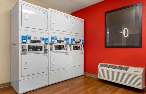 a room with a bunch of machines against a red wall at Extended Stay America Select Suites - Chicago - Hanover Park in Hanover Park