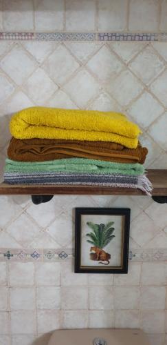 a pile of towels on a shelf with a picture at Casita Canaria in Santa Cruz de Tenerife