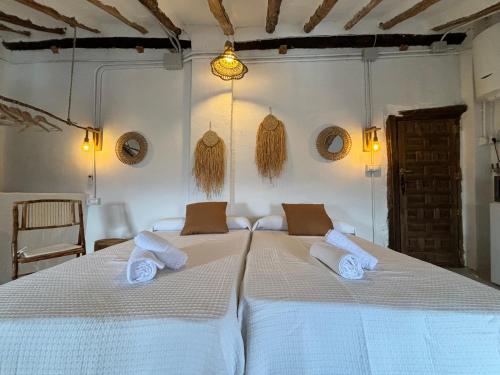 Un dormitorio con una cama blanca con toallas. en Alojamiento Verdala en Iznatoraf