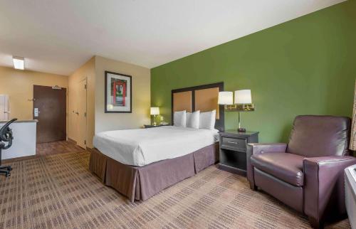 ブルーミントンにあるExtended Stay America Suites - Bloomington - Normalのベッドと椅子付きのホテルルーム