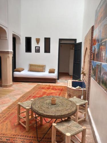 マラケシュにあるRiad Hostel JAD ZIADのテーブル、椅子、ベッドが備わる客室です。