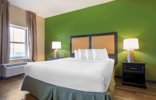 a large bed in a room with a green wall at Extended Stay America Suites - Chicago - O'Hare - Allstate Arena in Des Plaines