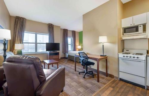 Habitación de hotel con cama y sala de estar. en Extended Stay America Suites - Chicago - O'Hare - Allstate Arena en Des Plaines