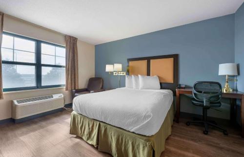 ein Hotelzimmer mit einem großen Bett und einem Schreibtisch in der Unterkunft Extended Stay America Suites - Chicago - Romeoville - Bollingbrook in Romeoville