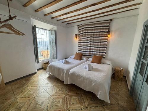 a bedroom with a bed and two windows at Alojamiento Manzanilla in Iznatoraf