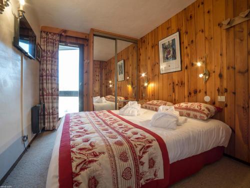 a bedroom with a large bed with wooden walls at Appartement Courchevel 1850, 3 pièces, 4 personnes - FR-1-575-35 in Courchevel