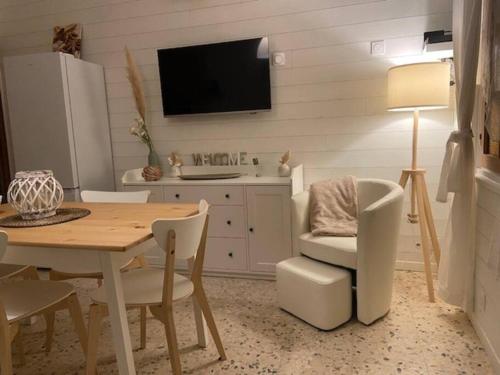 une salle à manger avec une table et une télévision dans l'établissement Maison au cœur du village de Gruissan, à Gruissan