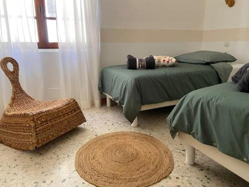 - une chambre avec 2 lits et un fauteuil en rotin dans l'établissement Maison au cœur du village de Gruissan, à Gruissan