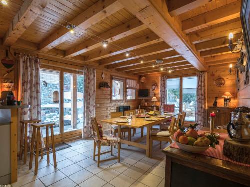 eine Küche und ein Esszimmer mit Tisch und Stühlen in der Unterkunft Chalet cosy à Courchevel La Tania - Idéal pour familles et amis, ski aux pieds ! - FR-1-575-31 in Courchevel