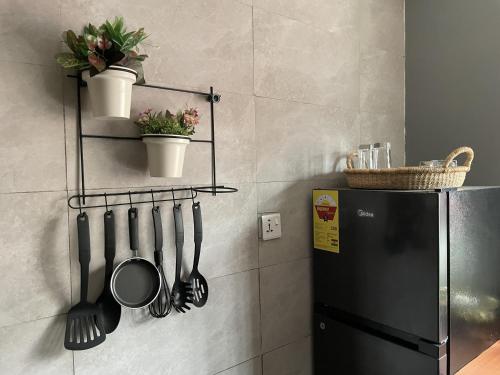 una cucina con un frigorifero nero e utensili su una parete di Tamaniroom- a private 1bed a Tamale