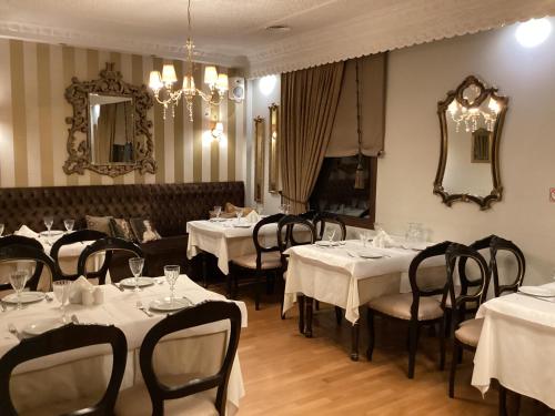 un restaurante con mesas y sillas blancas y un espejo en Οικία αποζαρι μικρή περσα, en Kastoria