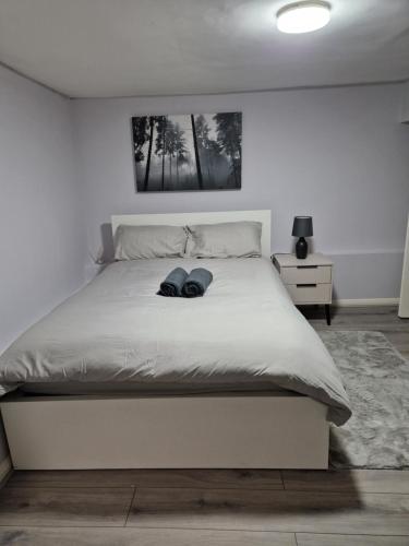 a bedroom with a white bed with two hats on it at Cosy Studio Apartment in London in London