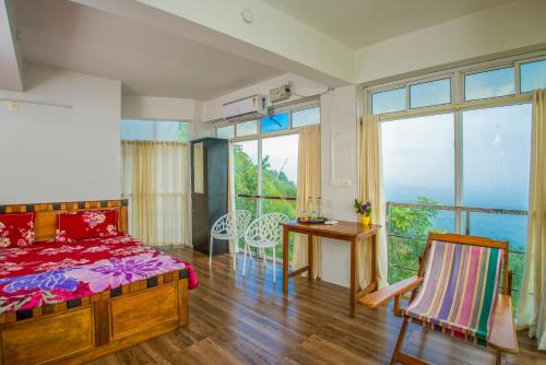 a bedroom with a bed and a table and chairs at CHILLAX Resorts Palakkayam THATTU in Paithalmala