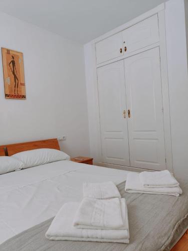 a bedroom with a white bed with two towels on it at Pita 1 in Níjar