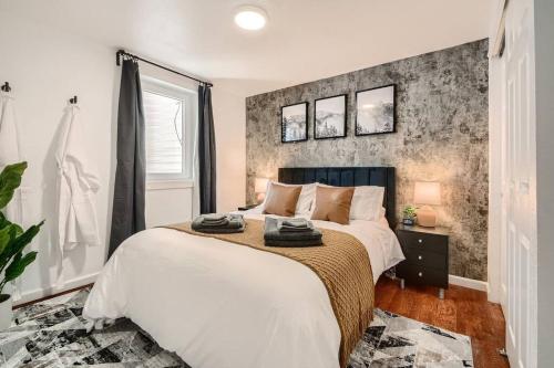 - une chambre avec un grand lit et un mur en briques dans l'établissement Adorable 2-Bedroom Modern Basement, à Denver