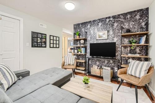 a living room with a couch and a tv at Adorable 2-Bedroom Modern Basement in Denver