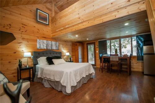 - une chambre avec un lit dans une pièce dotée de murs en bois dans l'établissement 3 Waterfront Cottages on Lake Sparrow - Sleeps 16, à Severn
