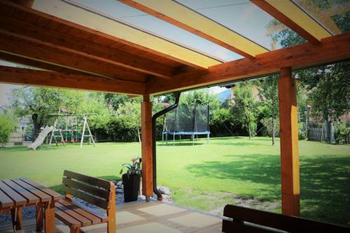 a patio with benches and a park with a playground at Appartements Umfahrer in Tröpolach
