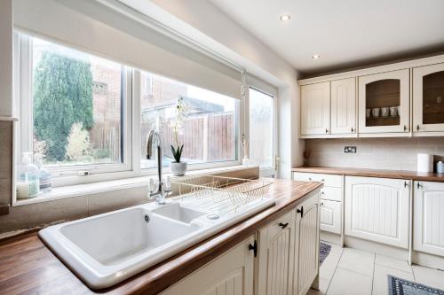 cocina con fregadero y ventana grande en LIVERPOOL HOME with FREE PARKING, en West Derby