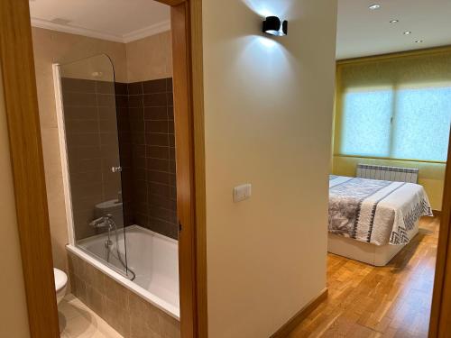 un bagno con letto e vasca accanto a una camera da letto di Piso nuevo totalmente equipado a Toro