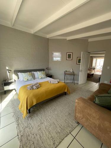 a bedroom with a large bed and a couch at The Cottage in Hermanus