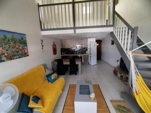 a living room with a yellow couch and a staircase at Pelican in Marigot