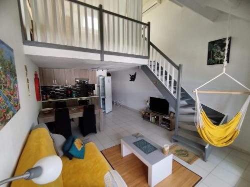 sala de estar con sofá amarillo y escalera en Pelican, en Saint Martin