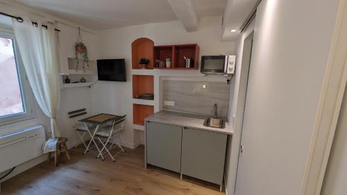 a small kitchen with a desk and a microwave at Casa Menton in Menton