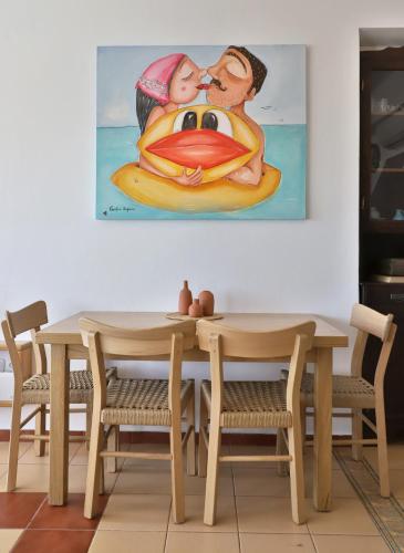 a table and chairs with a painting on the wall at Aqua Bliss in Xerokampos