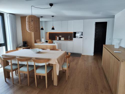 eine Küche und ein Esszimmer mit einem Tisch und Stühlen in der Unterkunft Apartamento T3 junto à ria e ao mar! in Gafanha da Nazaré