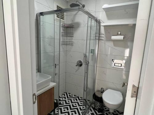 a bathroom with a shower with a toilet and a sink at The Yacht apartments-tranquiliti and comfort in the heard of Alanya 200m to Keykubat beach in Alanya