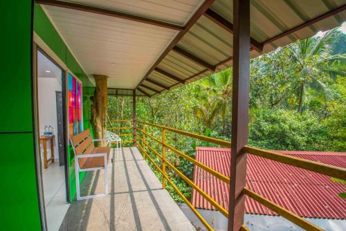 a balcony of a house with a table and a chair at NUTMEG COUNTY THABORE in Paithalmala