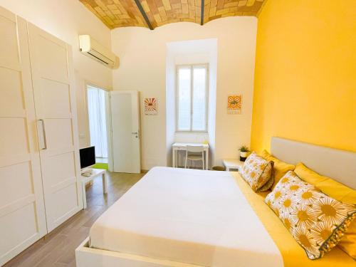 a bedroom with a large bed and a yellow wall at Casa Pesa 2 rooms 2 baths Rome center in Rome