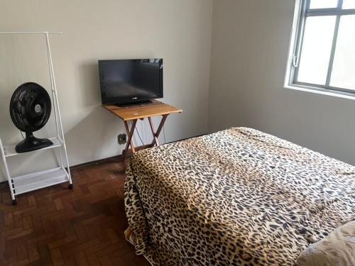 een slaapkamer met een bed en een televisie op een tafel bij Pousada ancora in Uberlândia