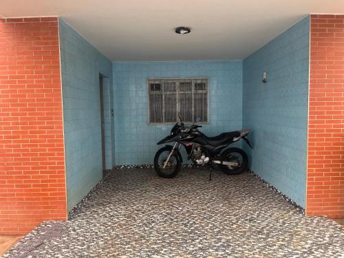 een motorfiets geparkeerd in een blauwe kamer met een bakstenen muur bij Pousada ancora in Uberlândia