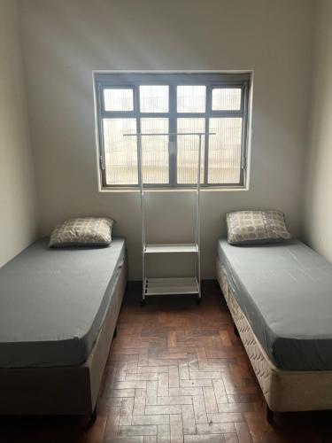 twee bedden in een kamer met twee ramen bij Pousada ancora in Uberlândia