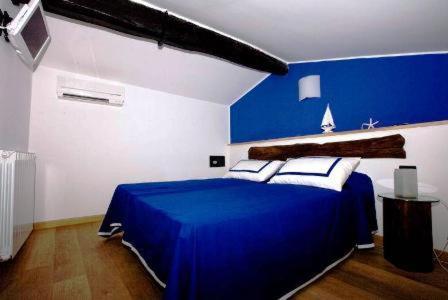 Dormitorio azul y blanco con cama azul en Affittacamere Da Cesare, en Monterosso al Mare