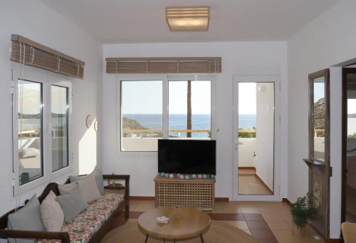 een woonkamer met een bank en een flatscreen-tv bij Aqua Bliss in Xerokampos