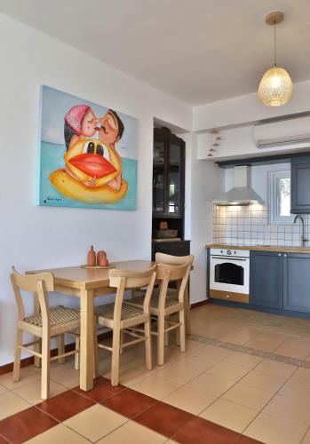 a kitchen with a table and chairs and a painting at Aqua Bliss in Xerokampos