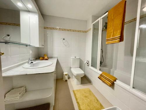 Baño blanco con lavabo y aseo en Apartamento con vistas al mar en Reserva de Marbella, en Marbella