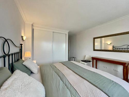 1 dormitorio con cama y espejo en Apartamento con vistas al mar en Reserva de Marbella, en Marbella