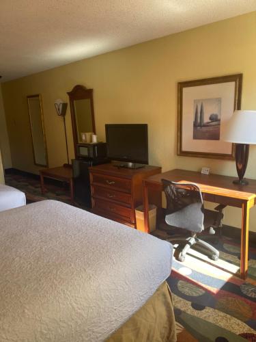 a hotel room with a desk and a bed at Budgetel Inn & Suites Atlanta in Atlanta