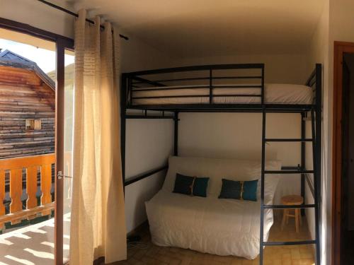 a bedroom with two bunk beds and a balcony at Studio Albiez-Montrond, 1 pièce, 4 personnes - FR-1-618-22 in Albiez-Montrond