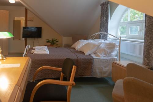 a bedroom with a bed and a chair and a window at Külalistemaja Kukruse Residents in Kohtla-Järve