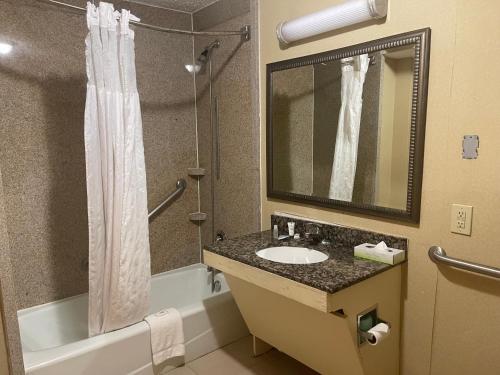 a bathroom with a sink and a tub and a shower at Budgetel Inn & Suites Atlanta in Atlanta