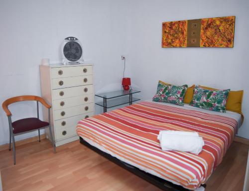 sypialnia z łóżkiem, krzesłem i komodą w obiekcie aparment puerto Alto w Madrycie