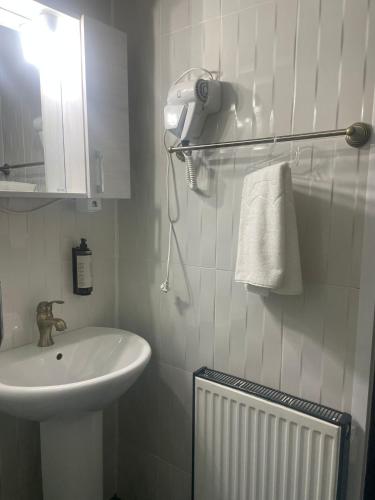 a white bathroom with a sink and a mirror at CASA BELLA in Ocna-Mureşului