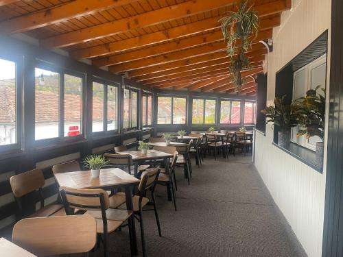 Ocna-Mureşului的住宿－CASA BELLA，用餐室设有桌椅和窗户。