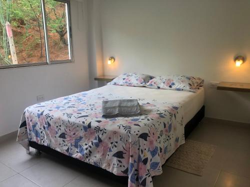 a bedroom with a bed with a comforter on it at Cabañas Annapurna in Taganga